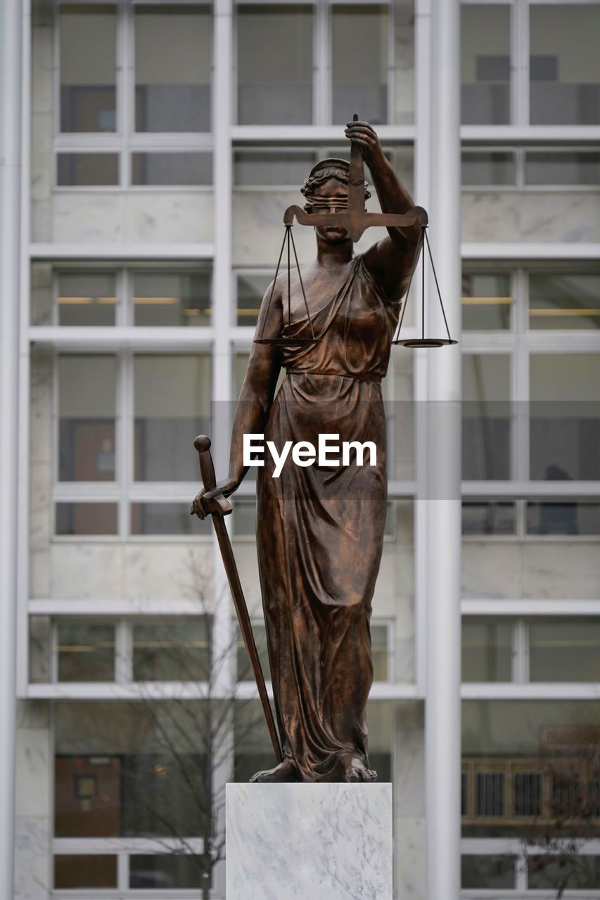 Lady justice statue in front of building