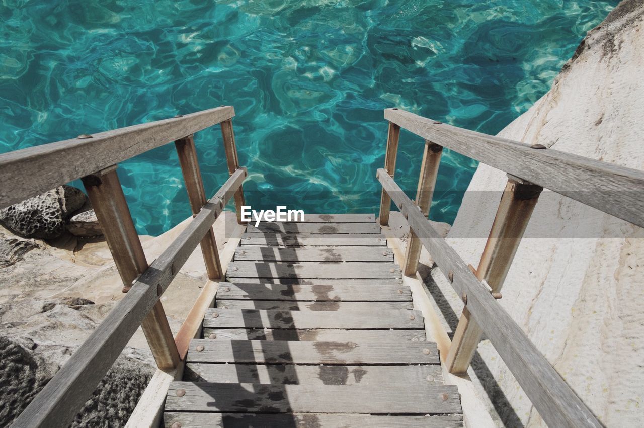 Wooden stairs leading to calm water