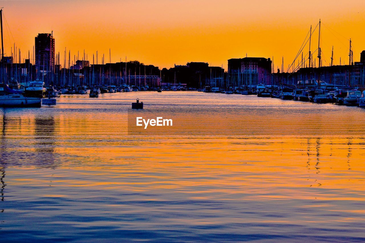 View of city at waterfront during sunset