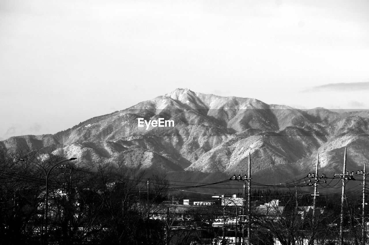 mountain, mountain range, snow, black and white, sky, scenics - nature, monochrome, beauty in nature, environment, monochrome photography, nature, landscape, no people, winter, cold temperature, tree, plant, snowcapped mountain, architecture, cloud, tranquil scene, tranquility, day, land, outdoors, travel destinations, built structure, building exterior, travel, non-urban scene, building