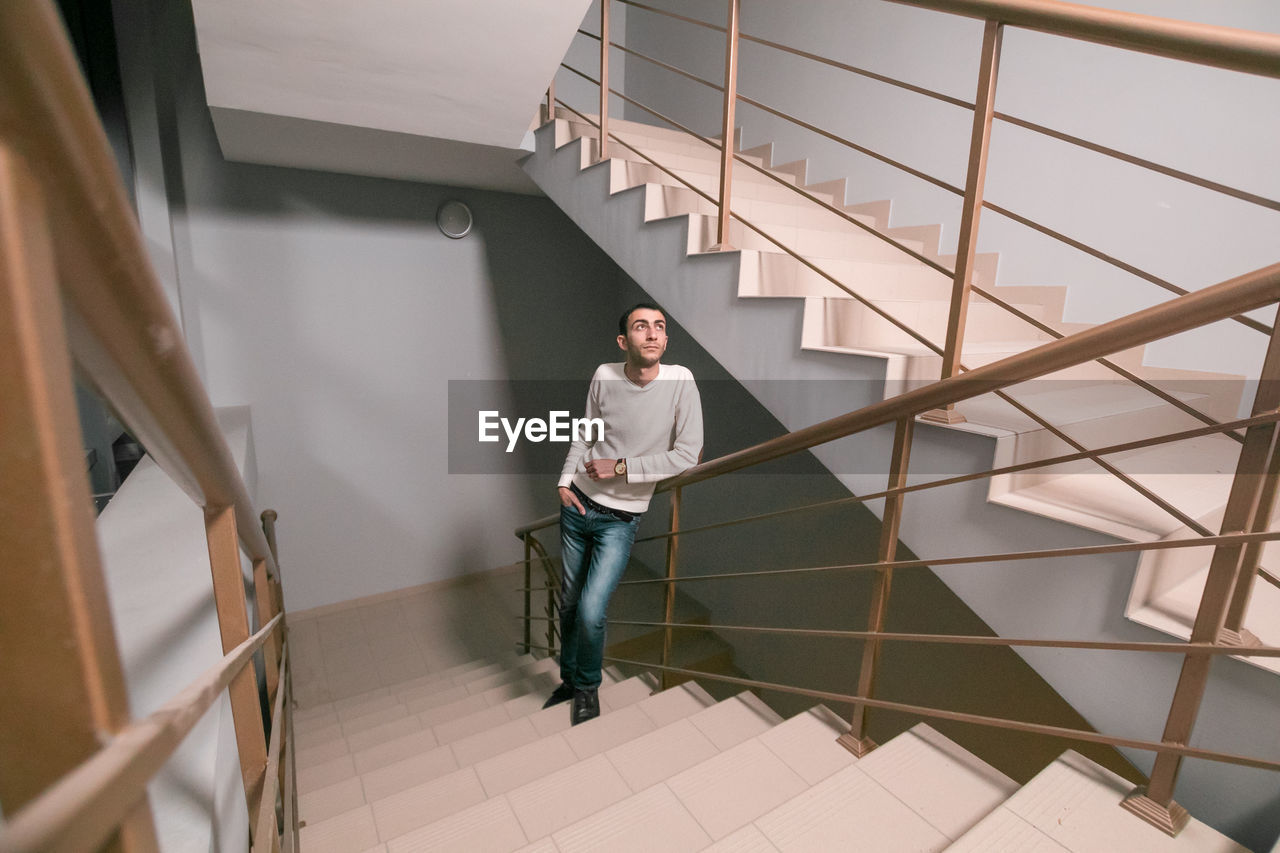 Young man standing on staircase