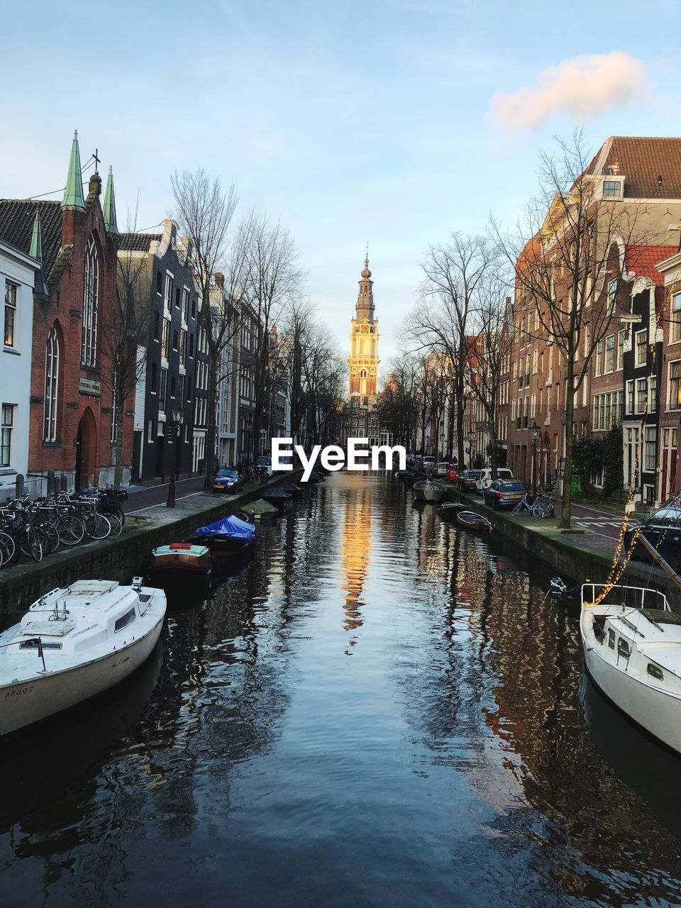 Boats moored on canal amidst buildings in city