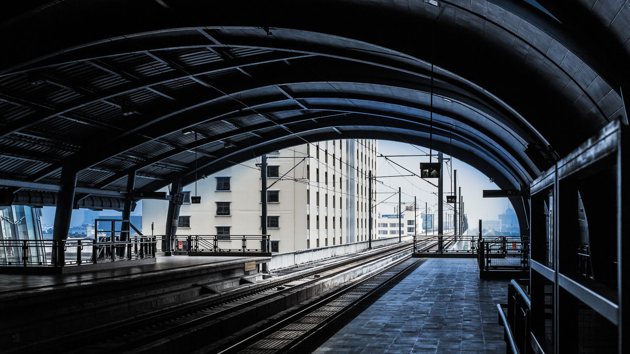 Empty railroad station against buildings