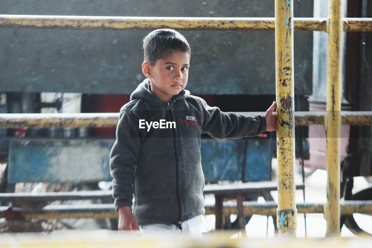 PORTRAIT OF BOY LOOKING THROUGH CAMERA