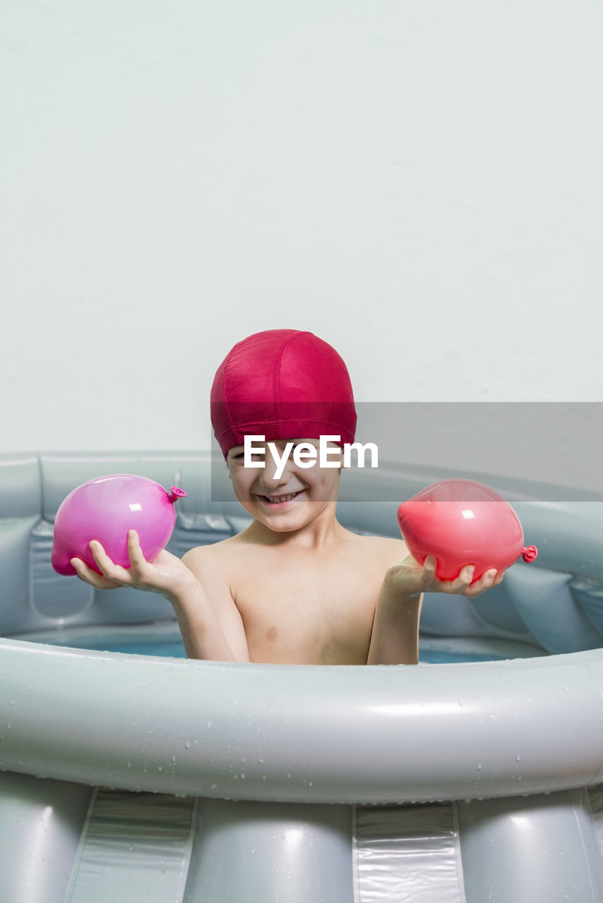 Portrait of smiling boy in inflatable pool