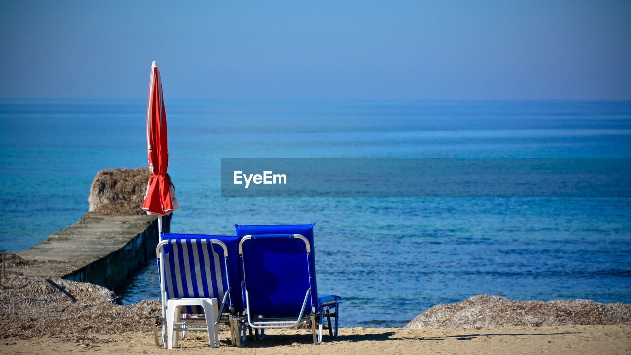 Deck chairs on shore at beach