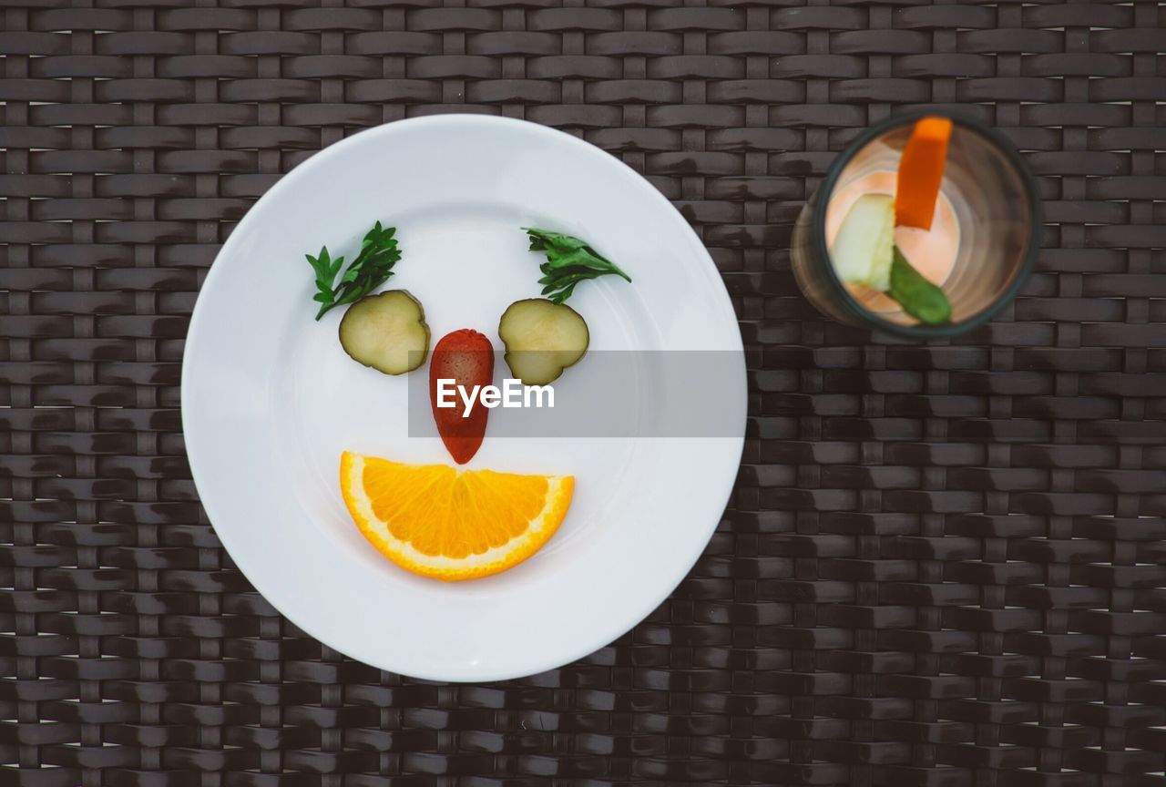 Directly above shot of fruits slices in plate on wicker table