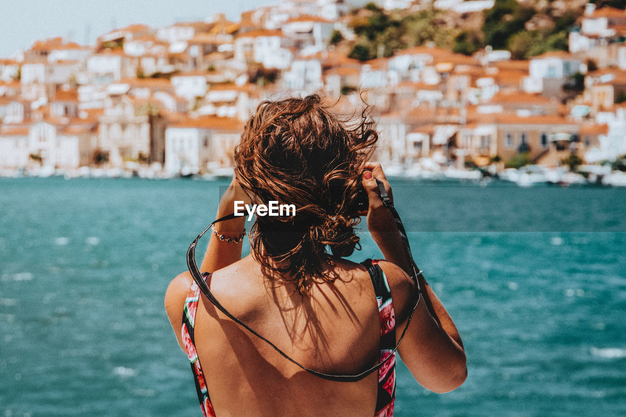 Rear view of woman standing against sea