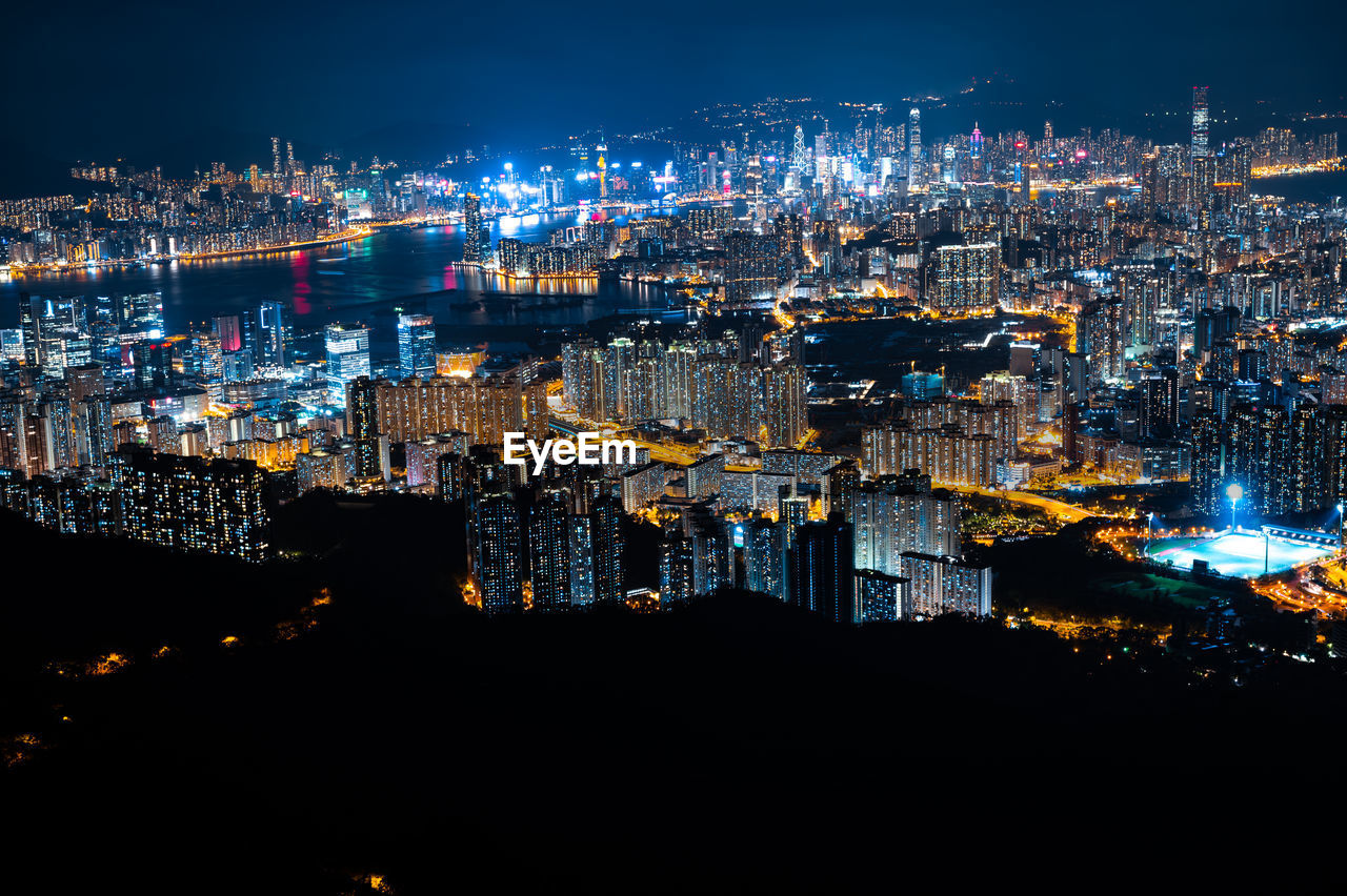 HIGH ANGLE VIEW OF ILLUMINATED CITY BUILDINGS AT NIGHT