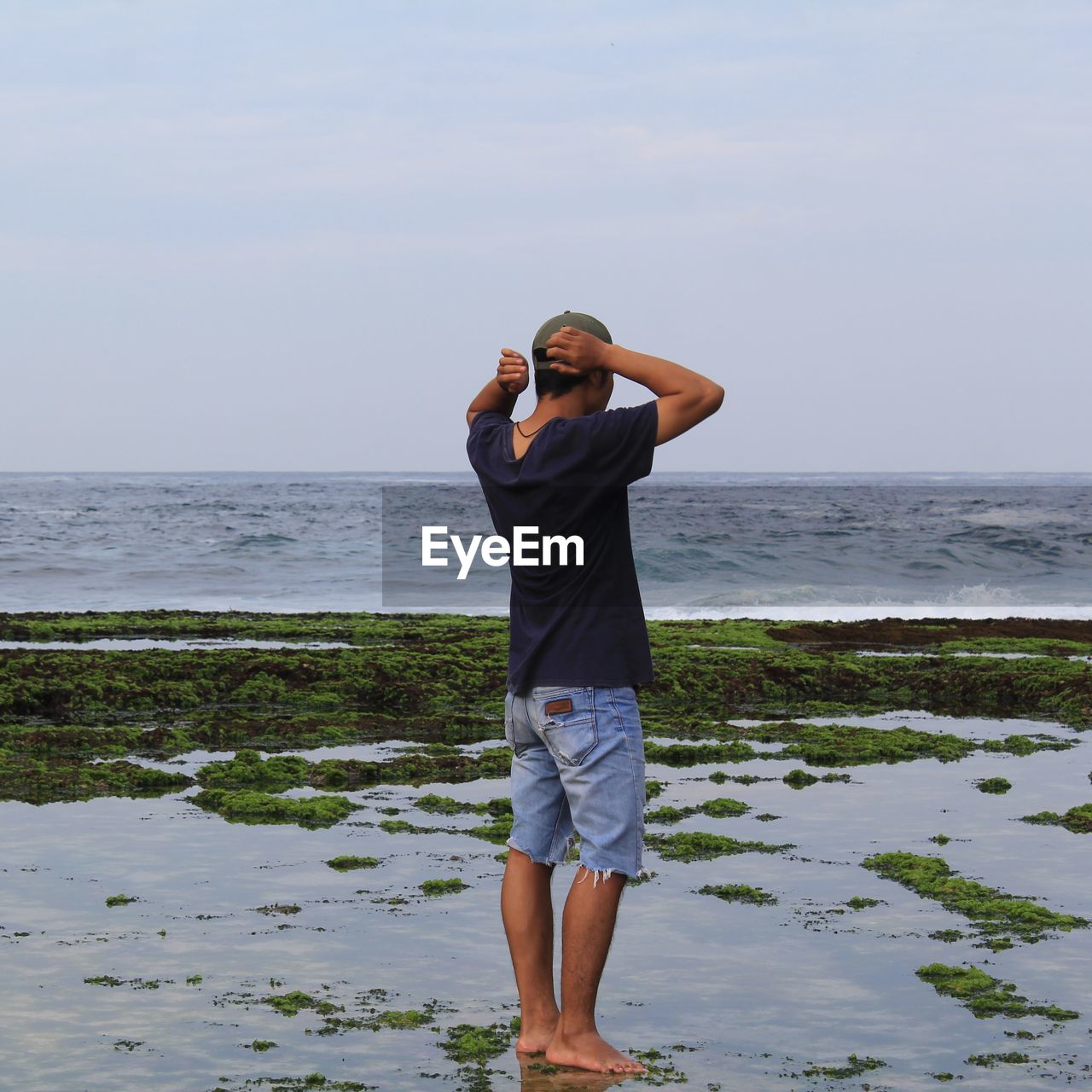 Full length of man standing on beach against sky