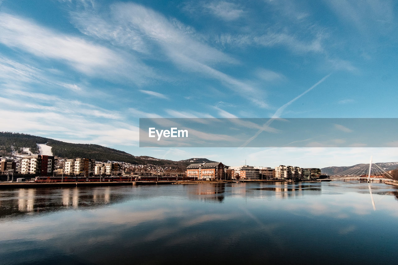 River by buildings against sky in city