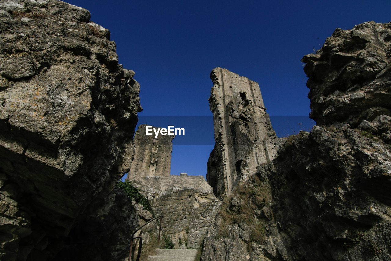 Low angle view of corfe castle against clear blue sky