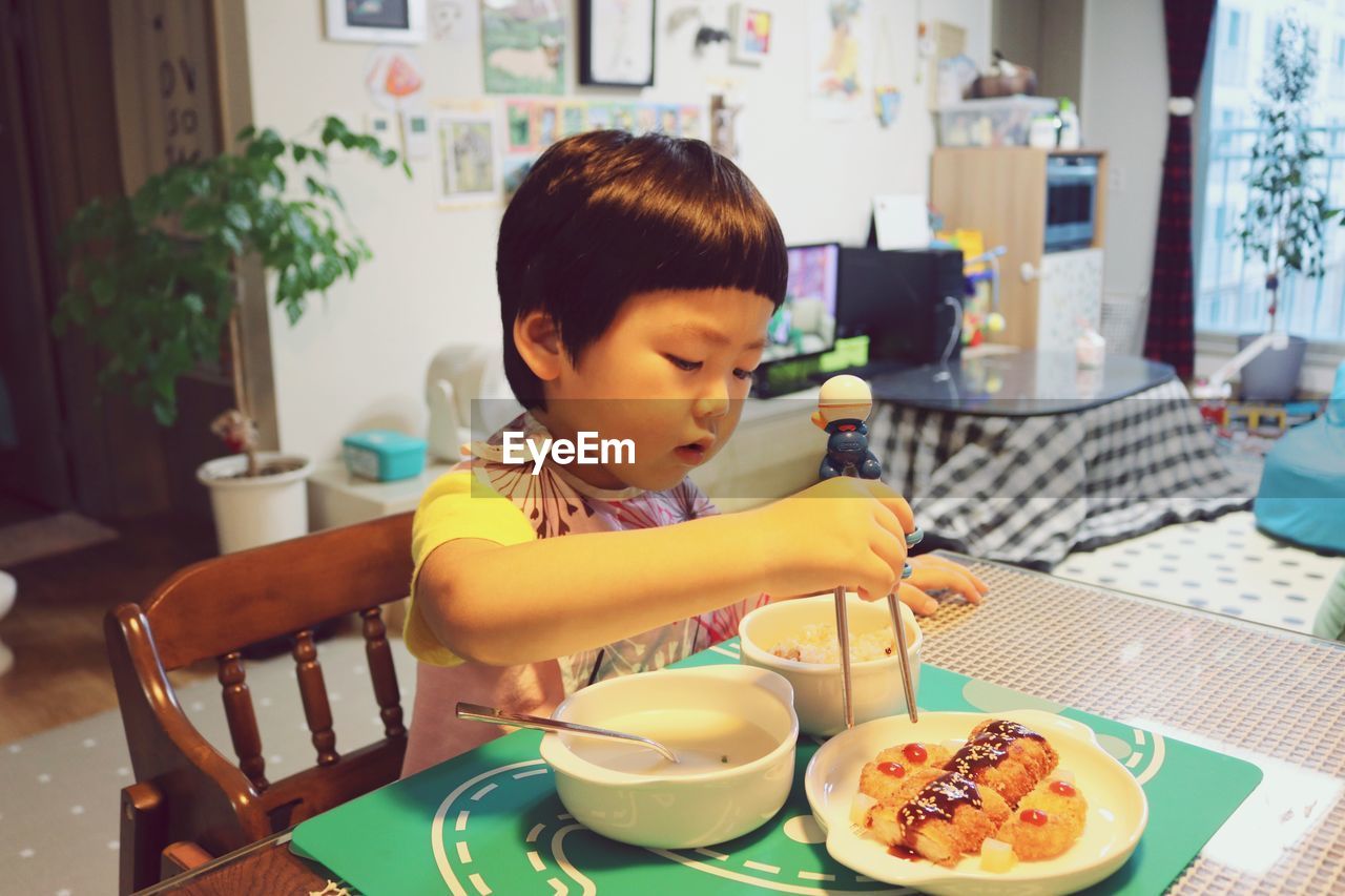 Boy having food at table