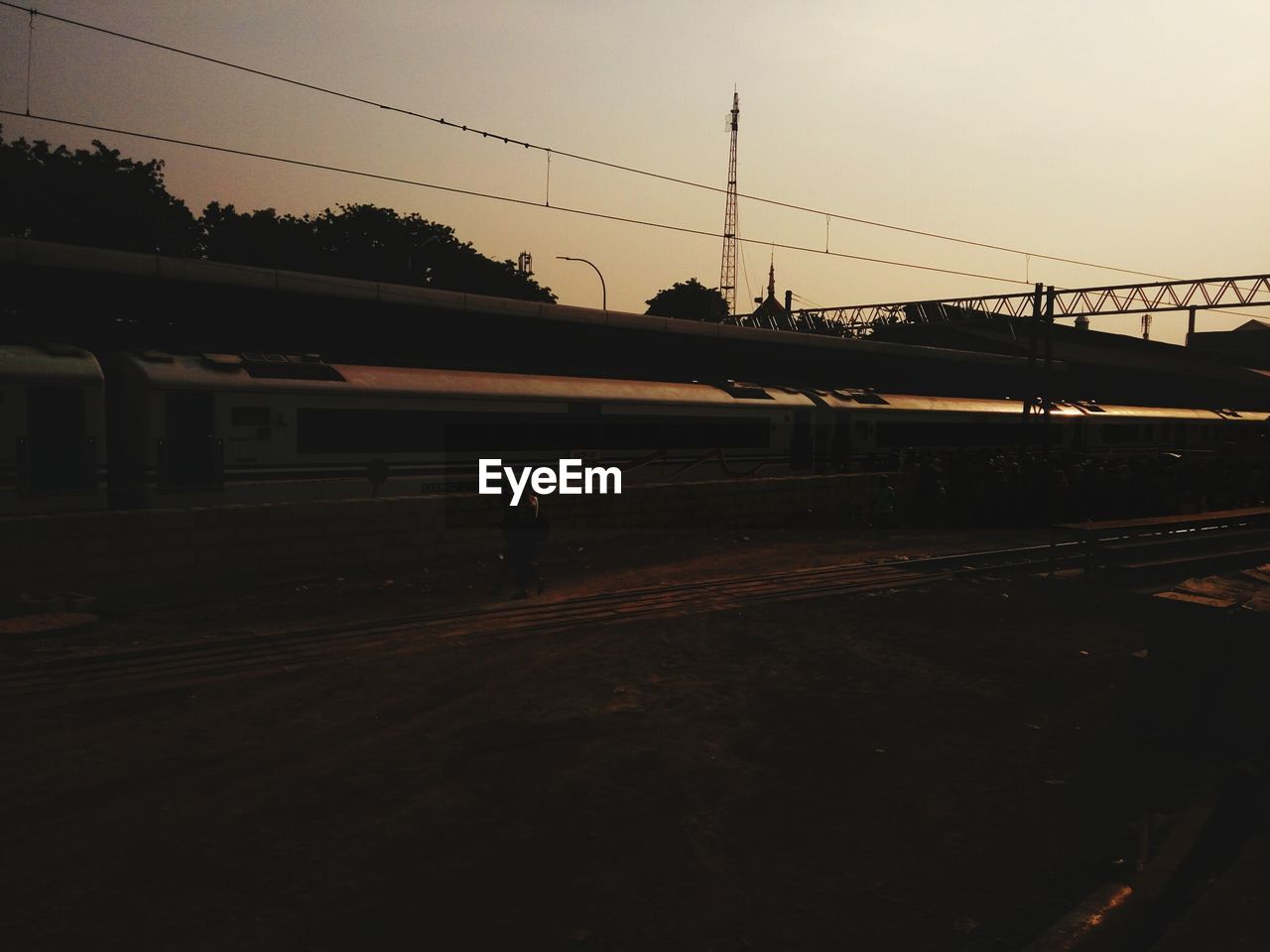 Train at railroad station against sky during sunset