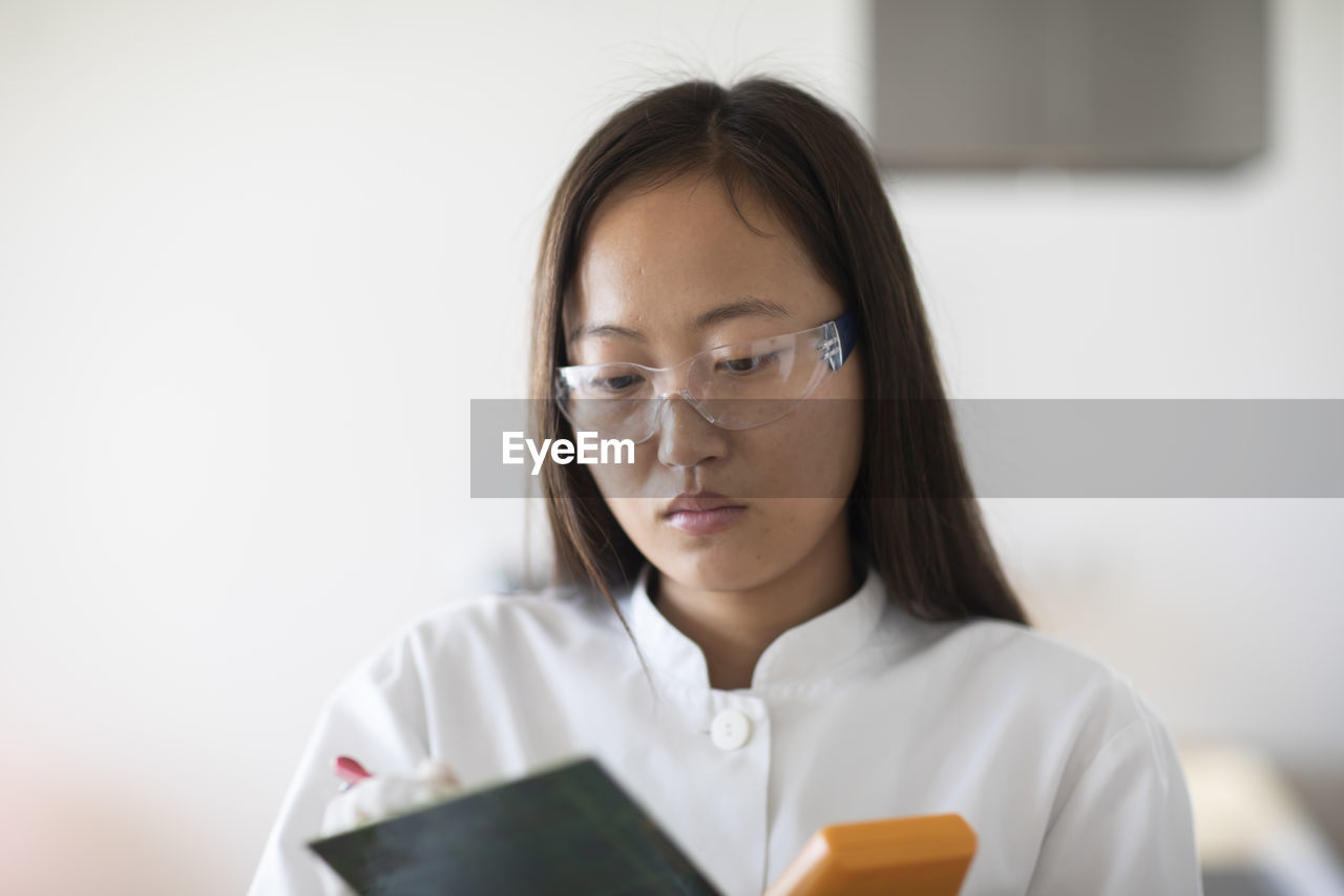 Scientist female with lab glasses and tablet in a lab