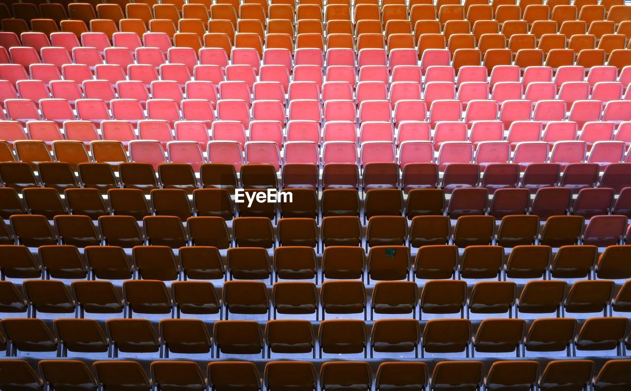 Full frame shot of empty red chairs in stage theater