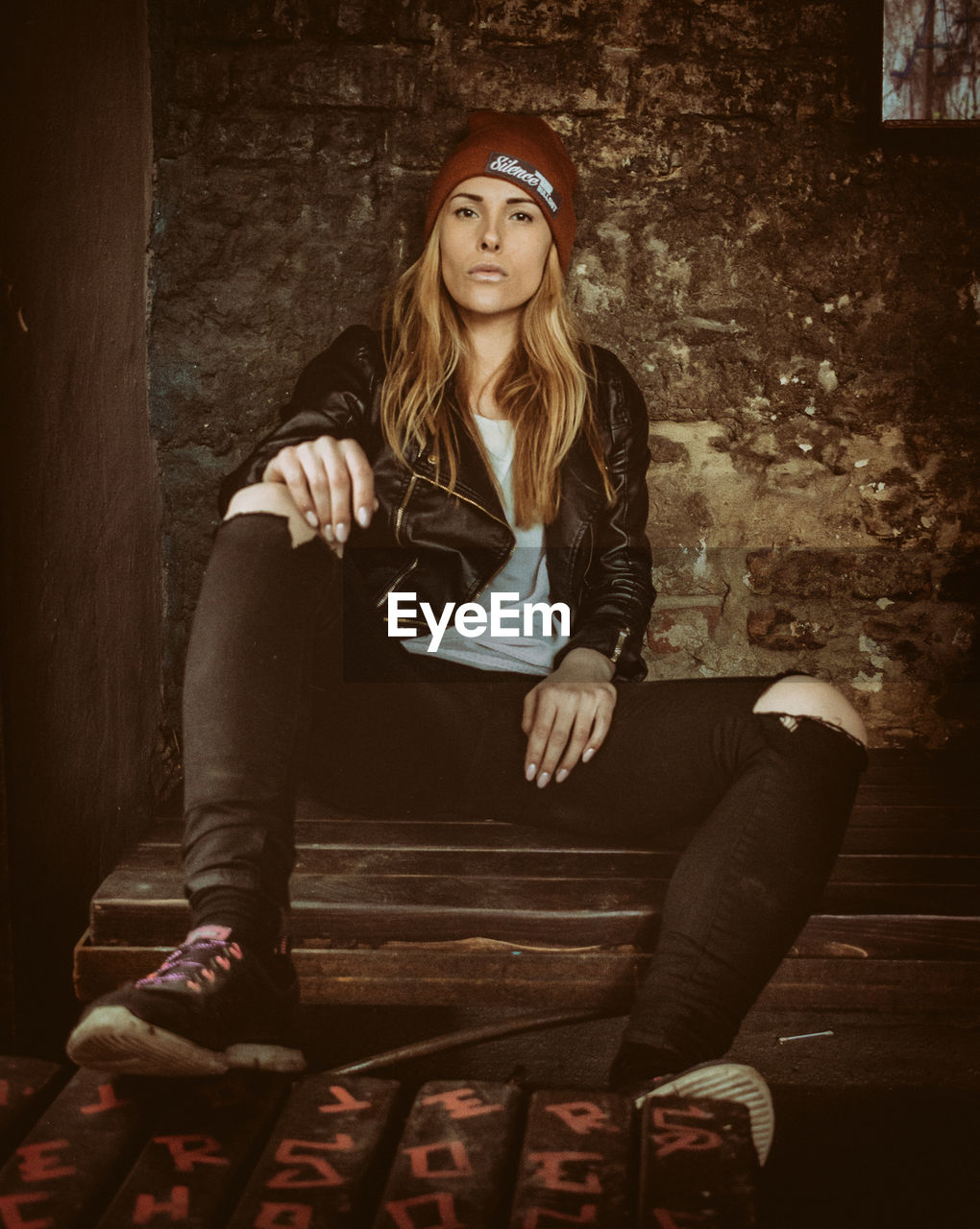 FULL LENGTH PORTRAIT OF YOUNG WOMAN SITTING ON FLOOR