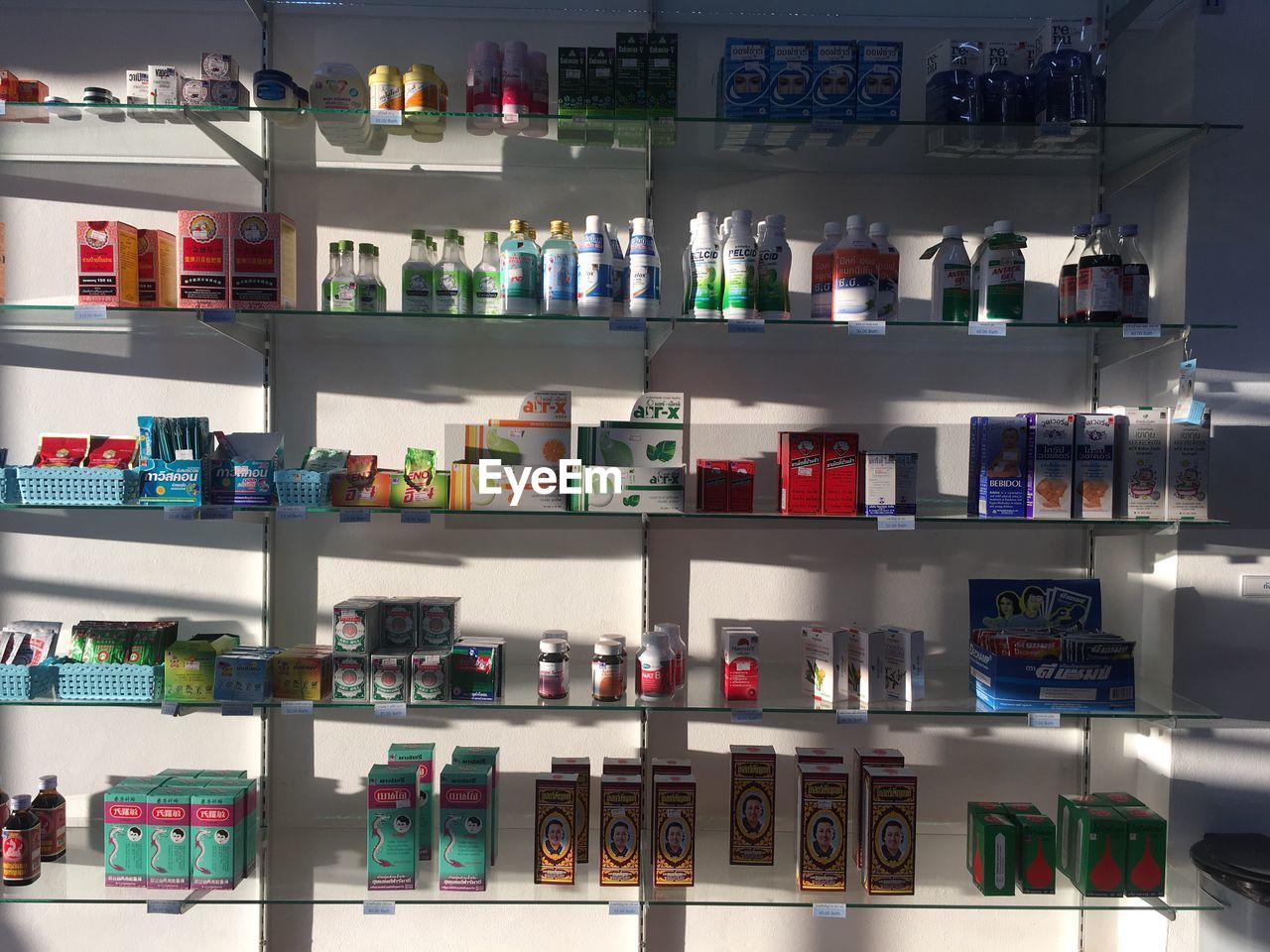 FULL FRAME SHOT OF MULTI COLORED BOTTLES IN SHELF