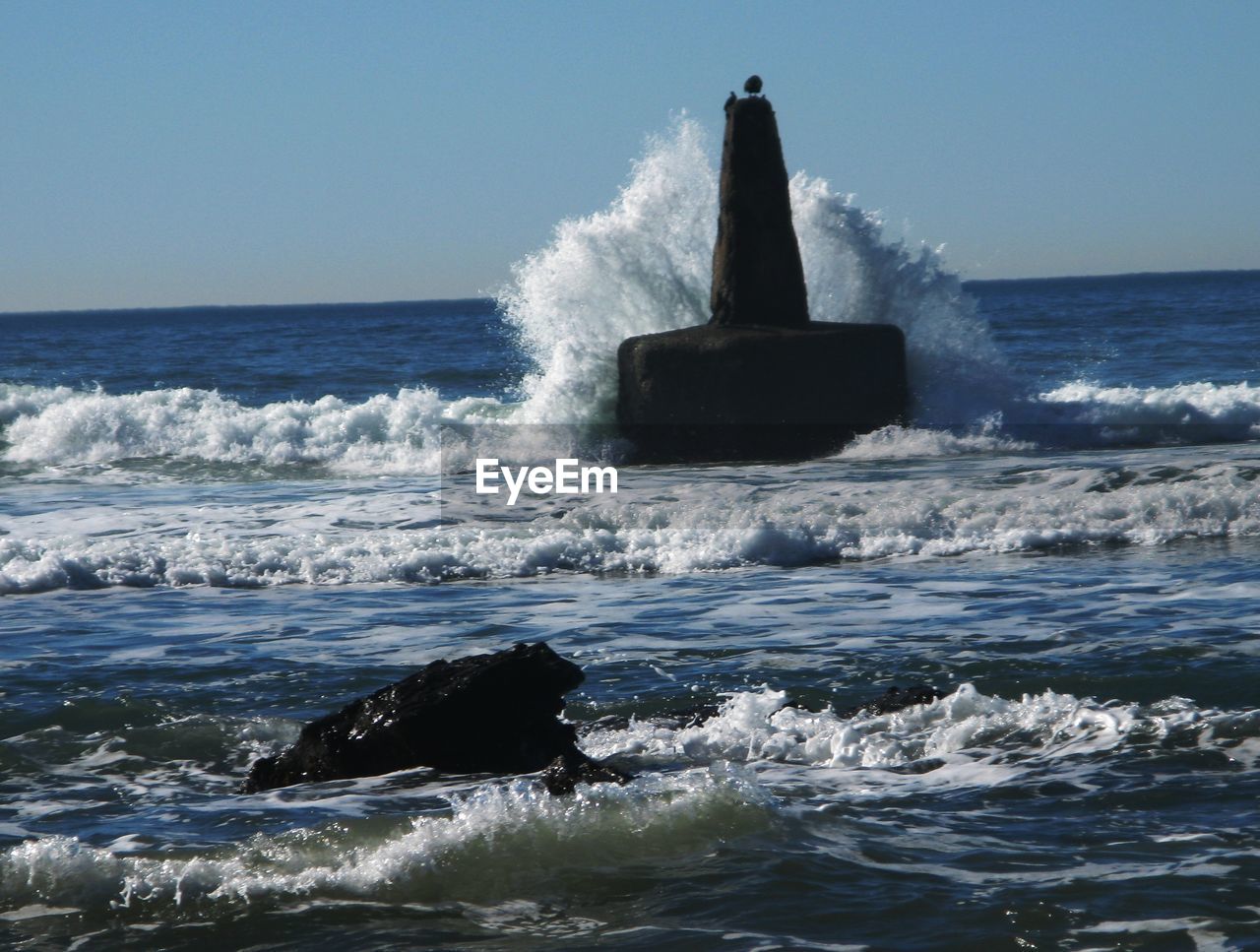 WAVES SPLASHING ON ROCKS AT SEA