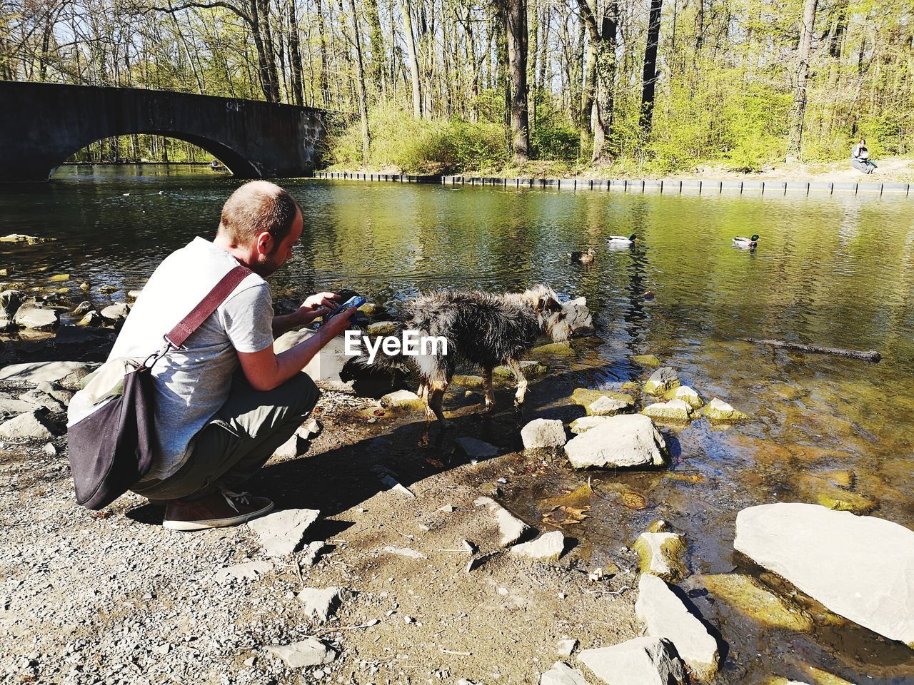 FULL LENGTH OF MAN SITTING AT LAKE