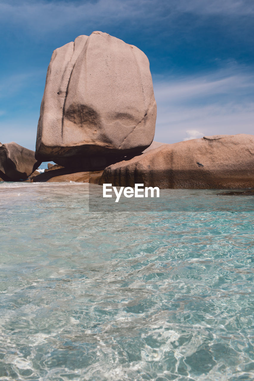 Rock formation in sea against sky