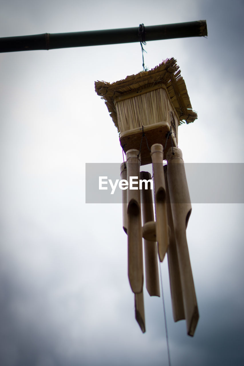 LOW ANGLE VIEW OF BELL HANGING AGAINST SKY