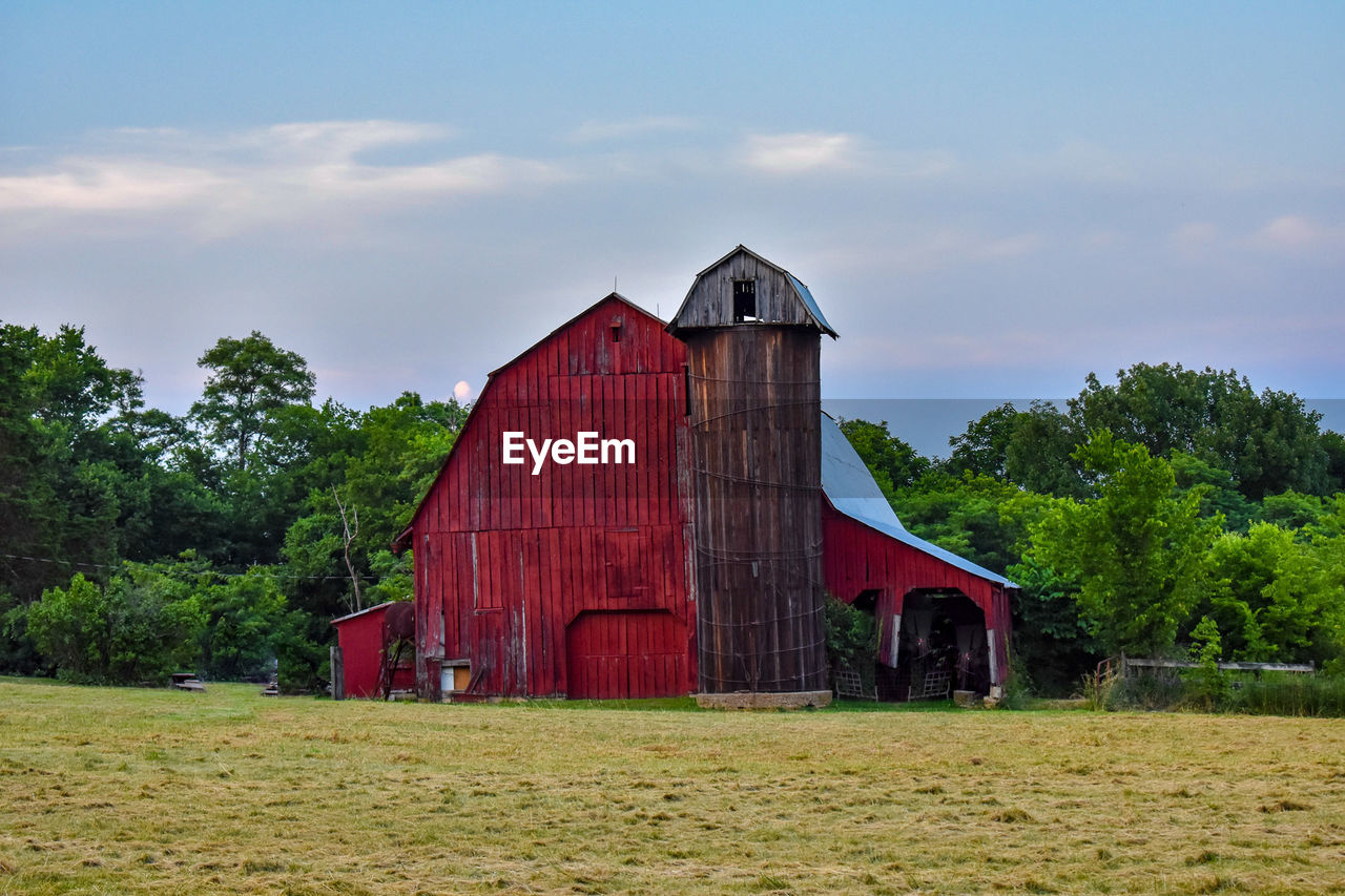 High angle view of barn on grassy field against sky