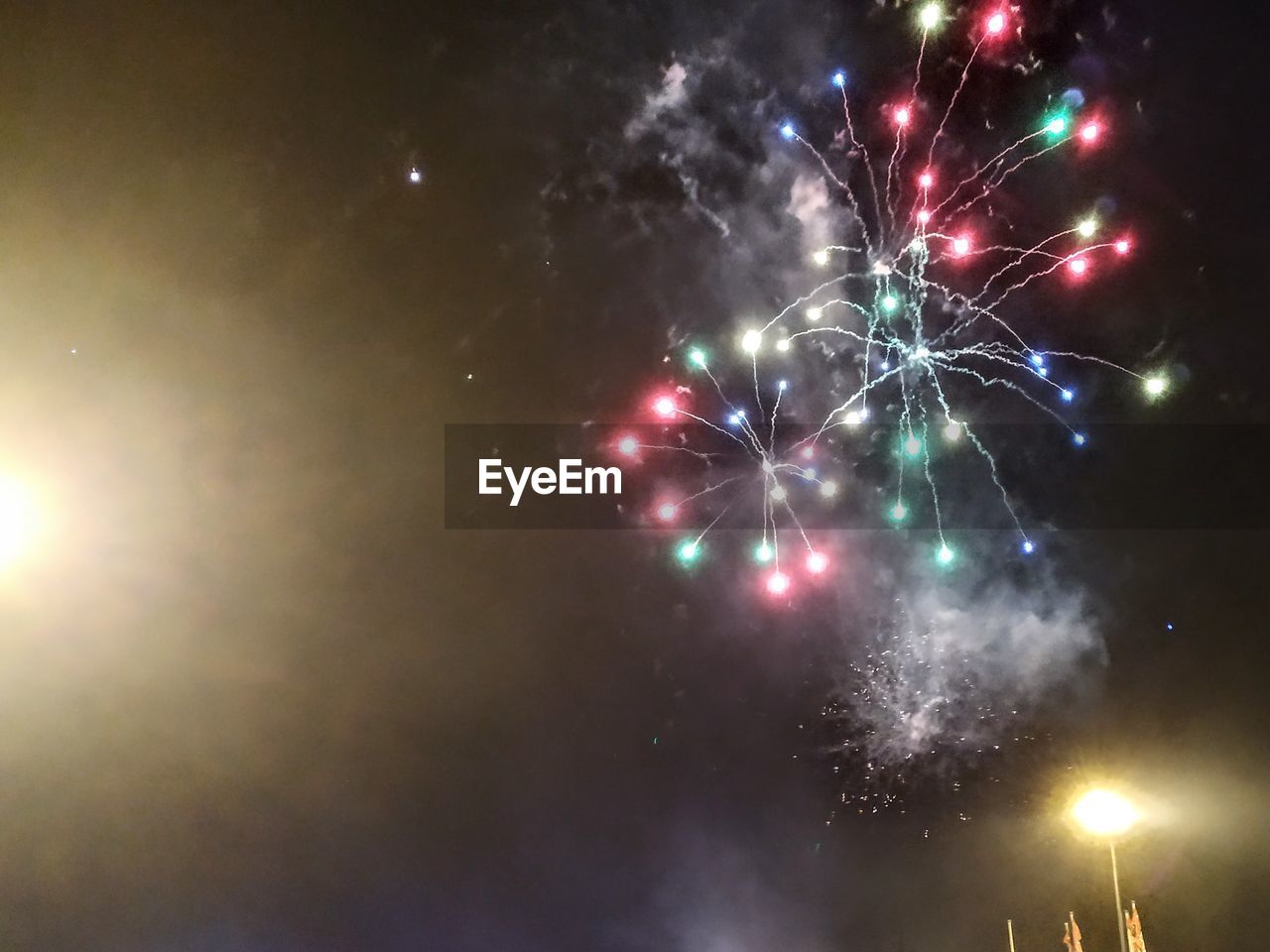 LOW ANGLE VIEW OF FIREWORKS IN SKY