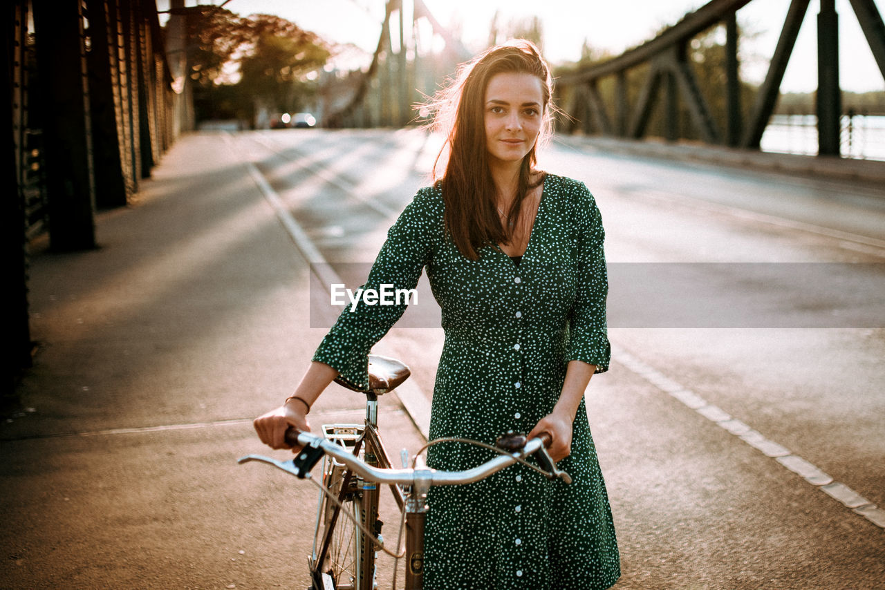 PORTRAIT OF SMILING WOMAN RIDING BICYCLE