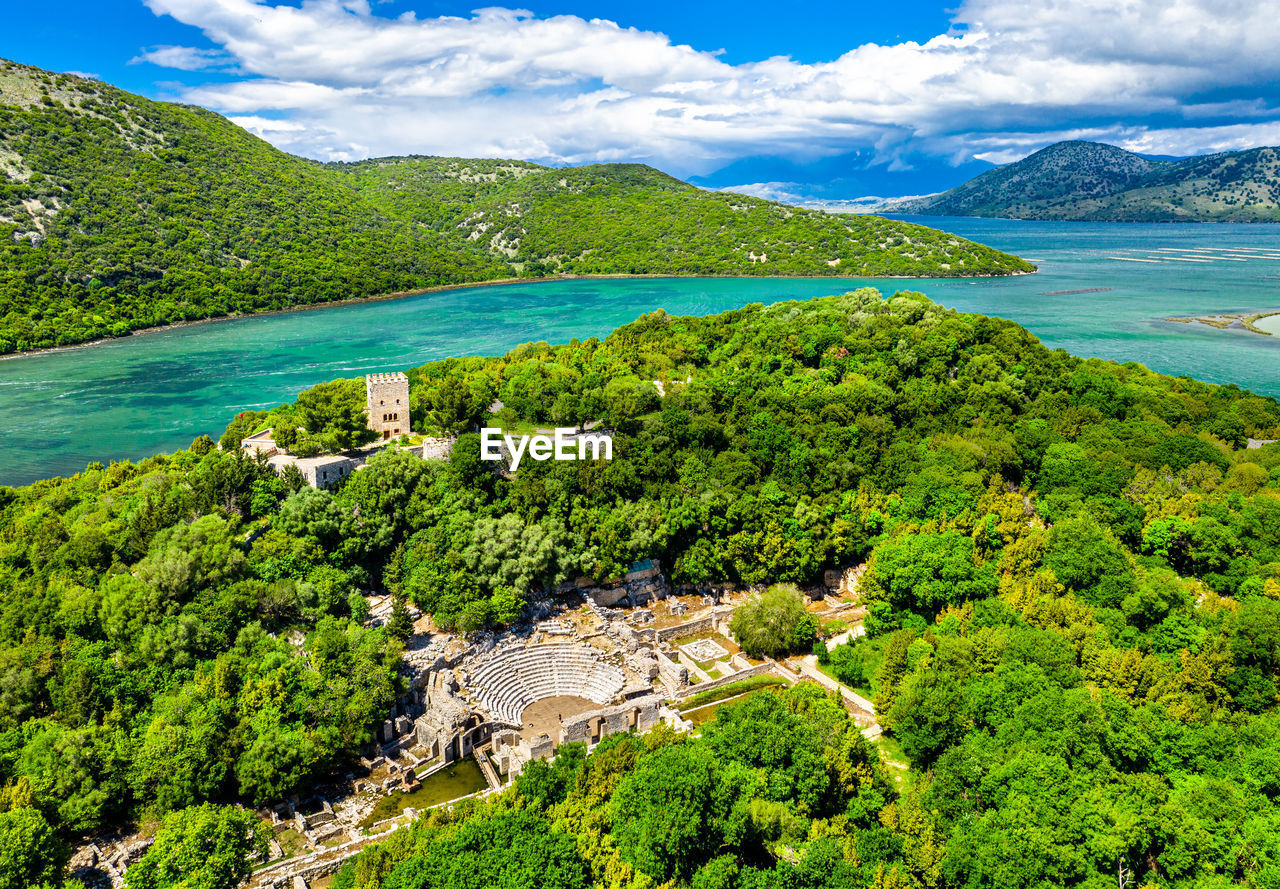 SCENIC VIEW OF SEA BY TREE MOUNTAINS AGAINST SKY