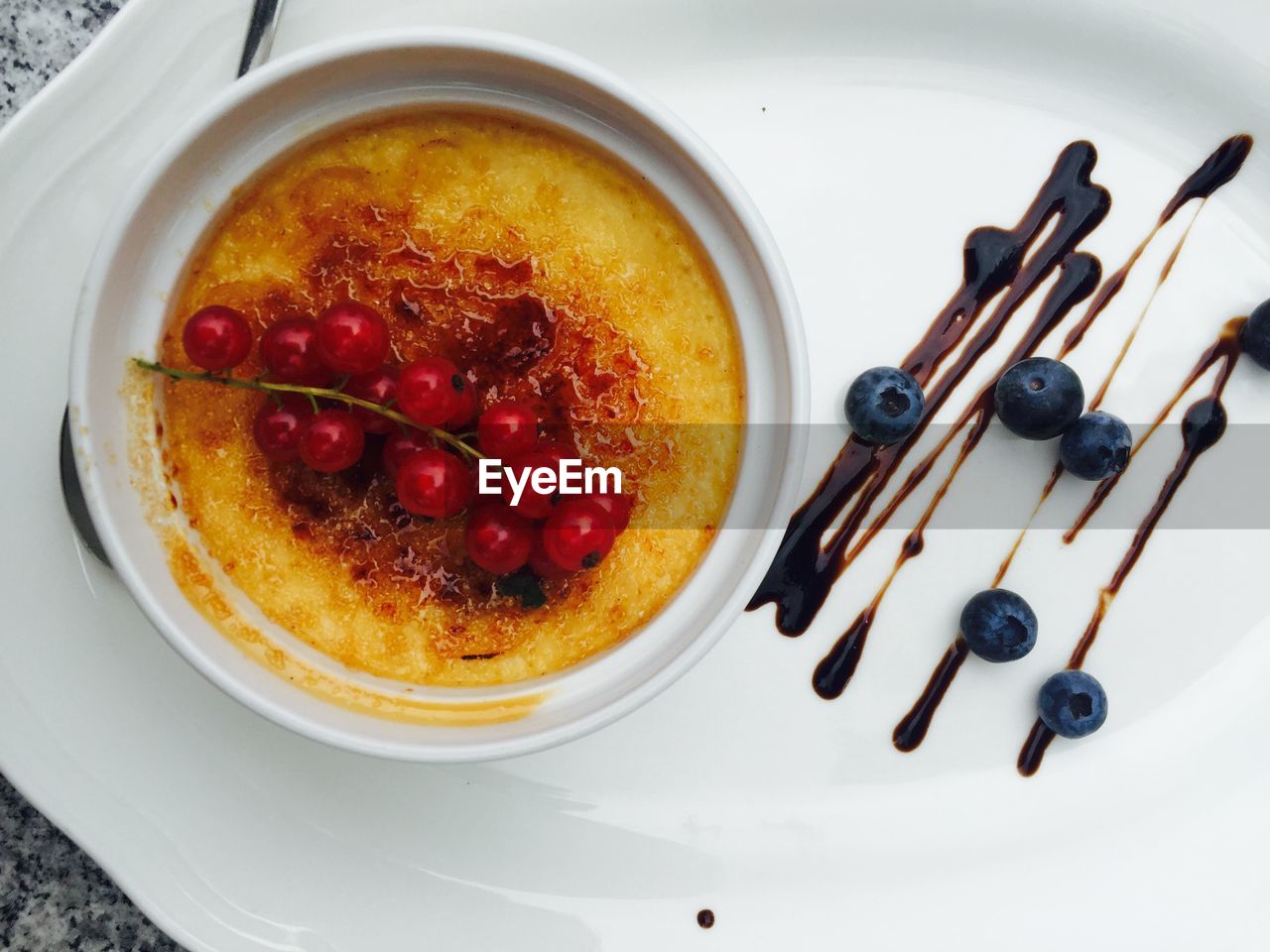 Close-up of creme brulee with berries served in bowl in plate