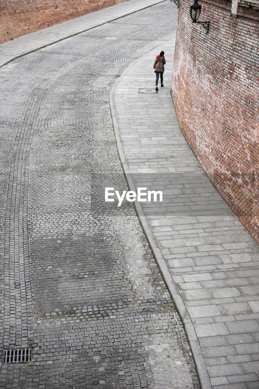 Rear view of woman walking on road