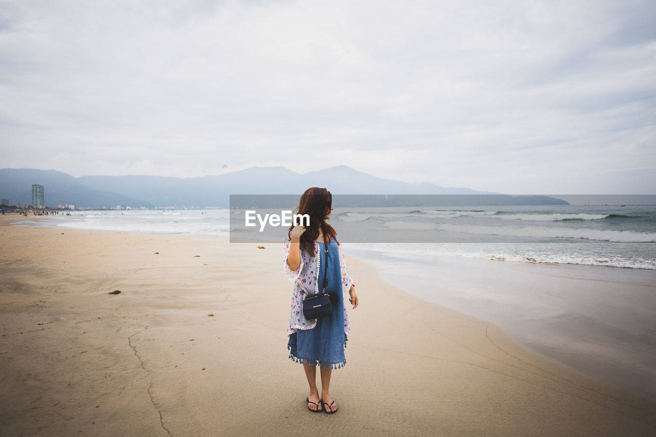 Woman standing on shore at beach