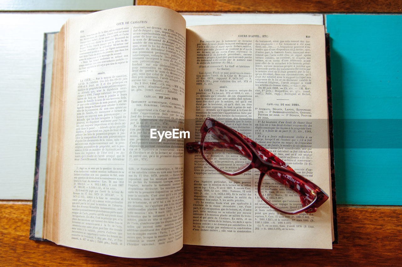 Directly above shot of eyeglasses on open book at table