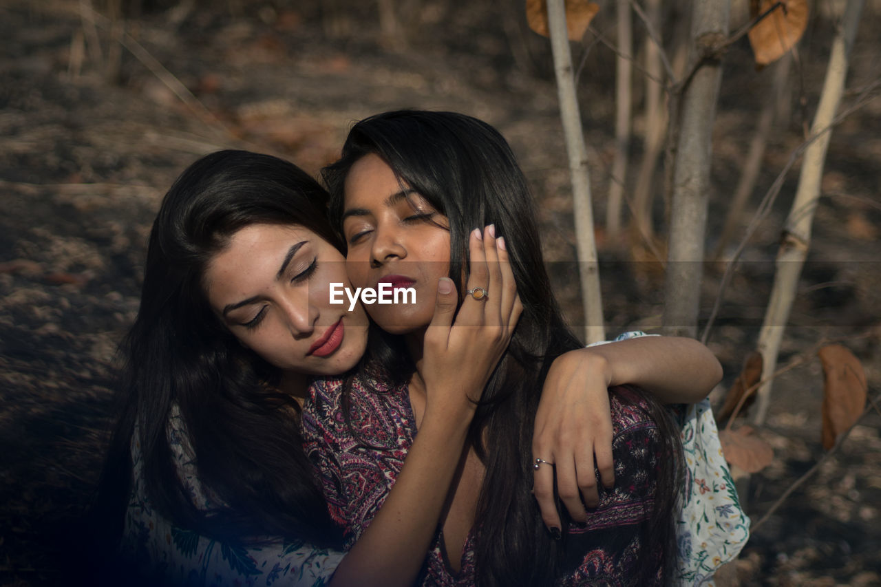 Lesbian couple romancing in forest 