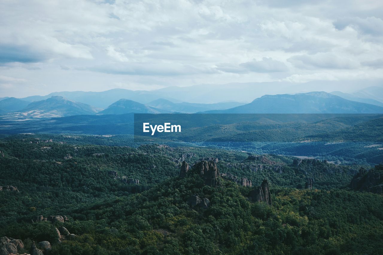 Scenic view of mountain range against cloudy sky