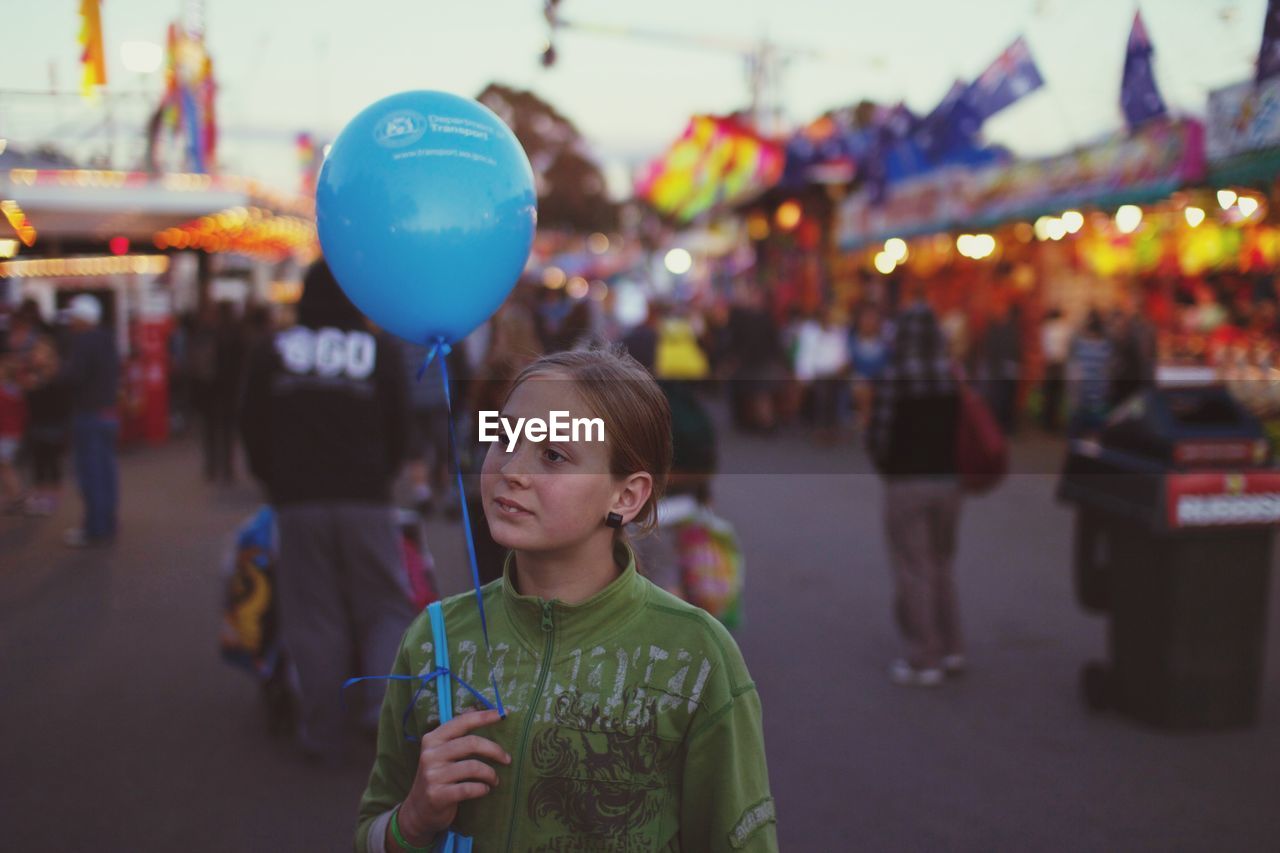 PORTRAIT OF BOY HOLDING BALLOONS AT FESTIVAL