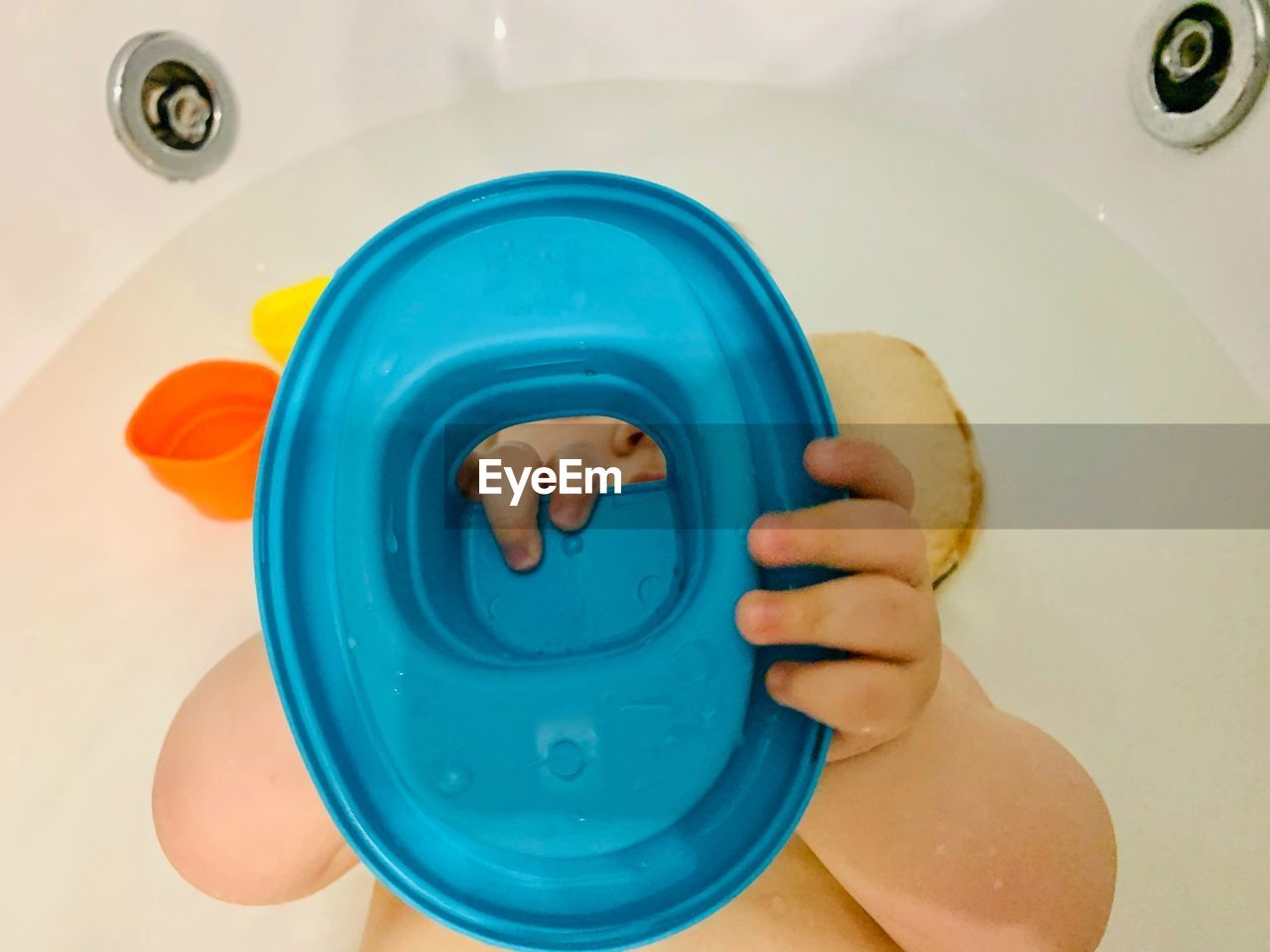 Directly above shot of boy playing with toy in bathroom