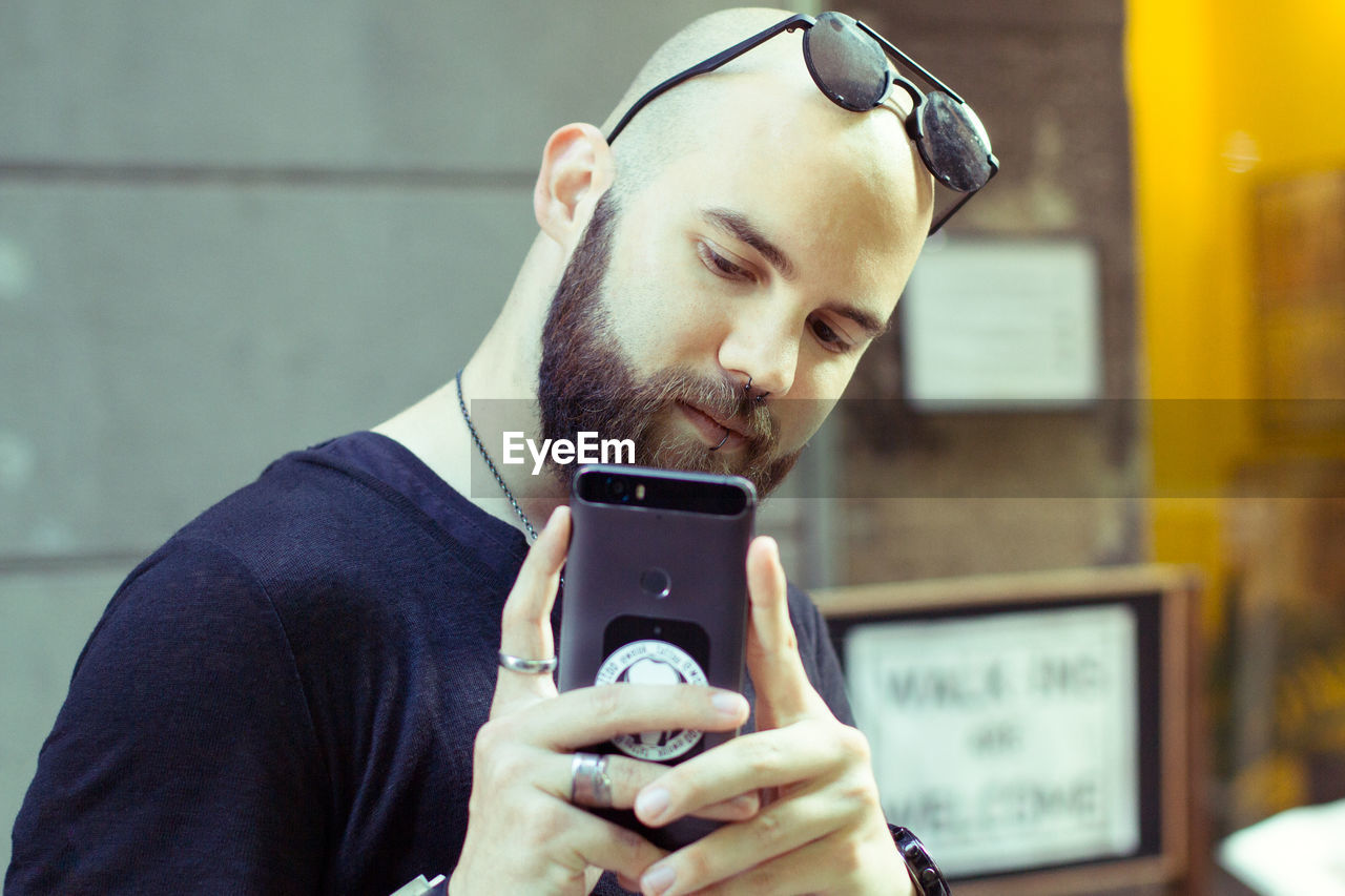 Bald man taking selfie with mobile phone