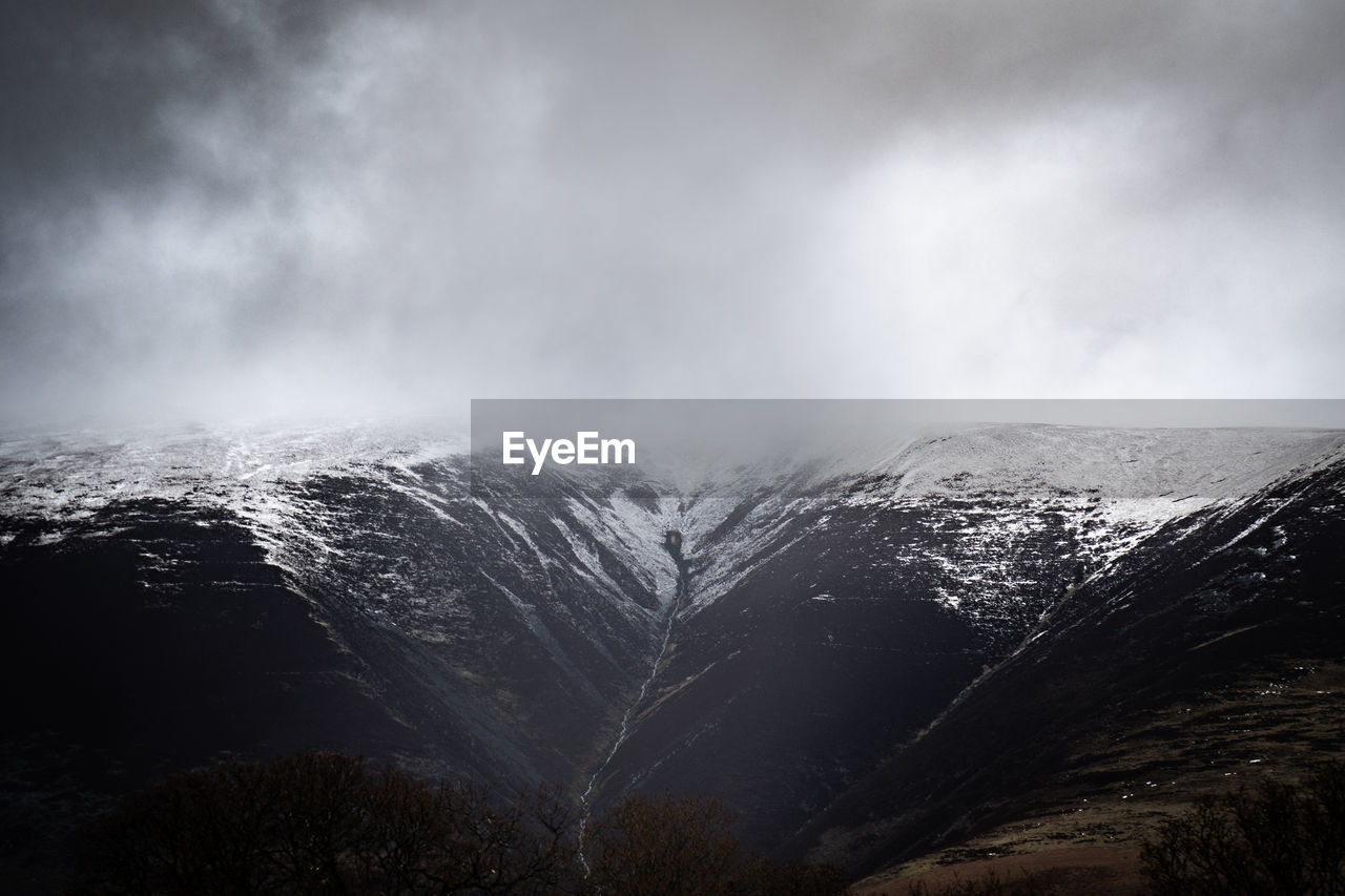 View of snowcapped mountain against cloudy sky