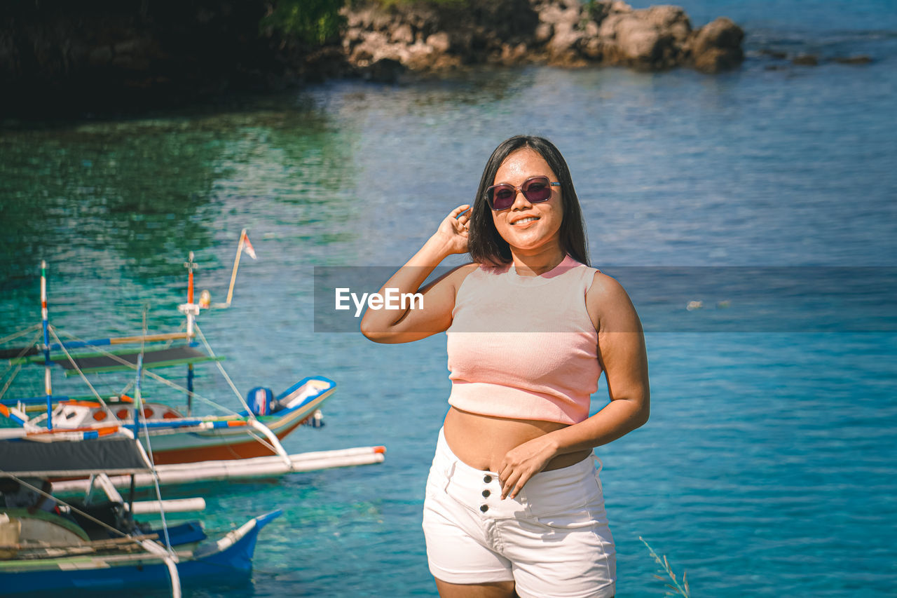 Portrait of young woman sitting in boat in lake