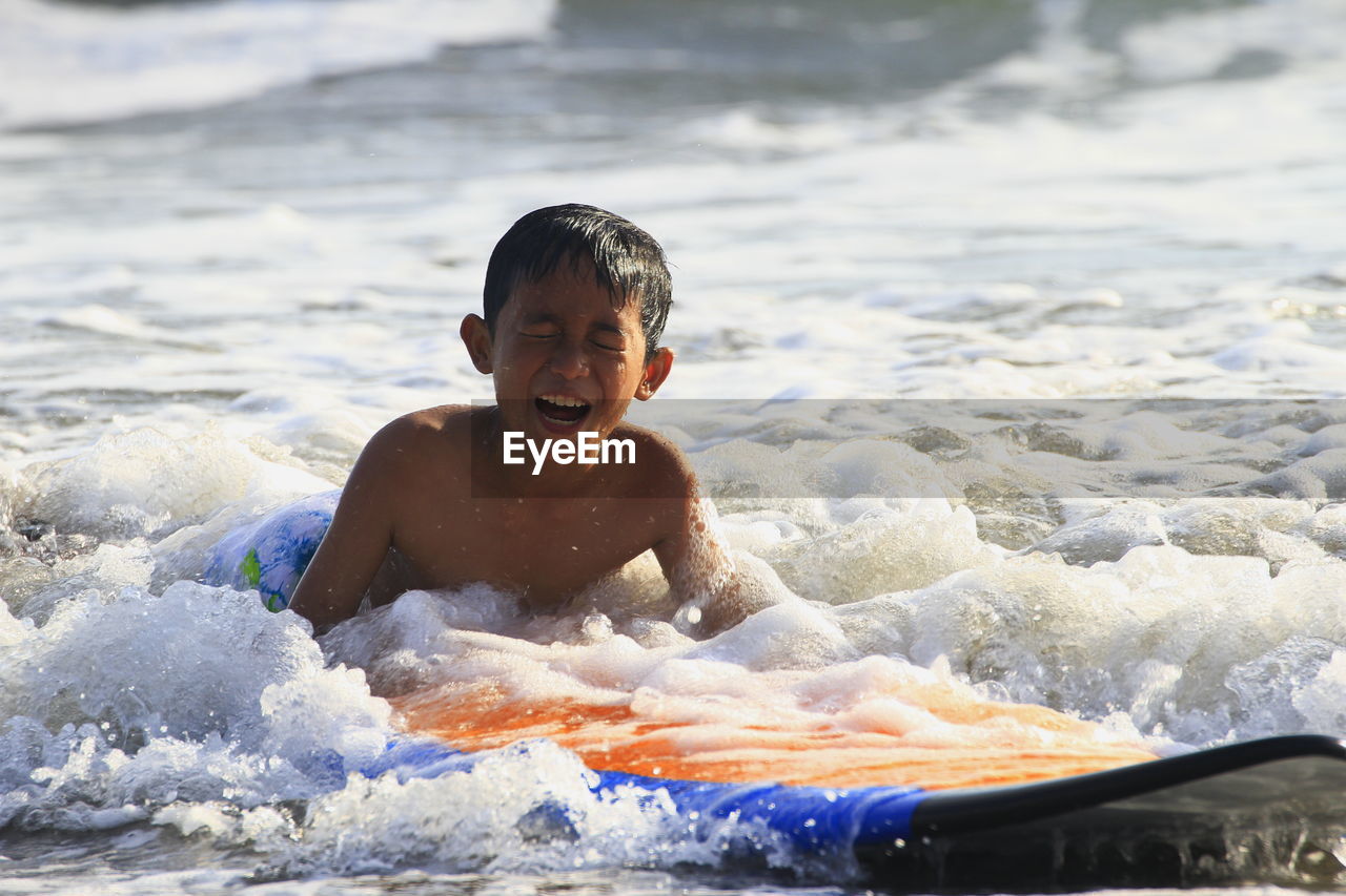 Portrait of shirtless boy in sea