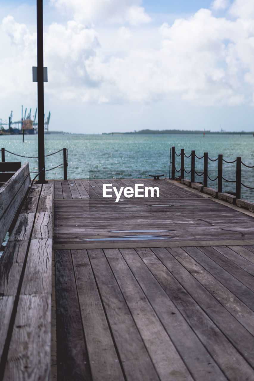 sky, wood, walkway, water, pier, boardwalk, sea, cloud, nature, scenics - nature, coast, dock, ocean, jetty, shore, beauty in nature, tranquility, land, horizon, tranquil scene, beach, day, no people, architecture, horizon over water, outdoors, travel destinations, holiday, idyllic, deck, travel, trip, vacation, railing, the way forward, footpath, blue, built structure, nautical vessel, seascape, landscape, transportation, environment, non-urban scene, post, tourism, sunlight, bay, summer, empty, relaxation, wooden post