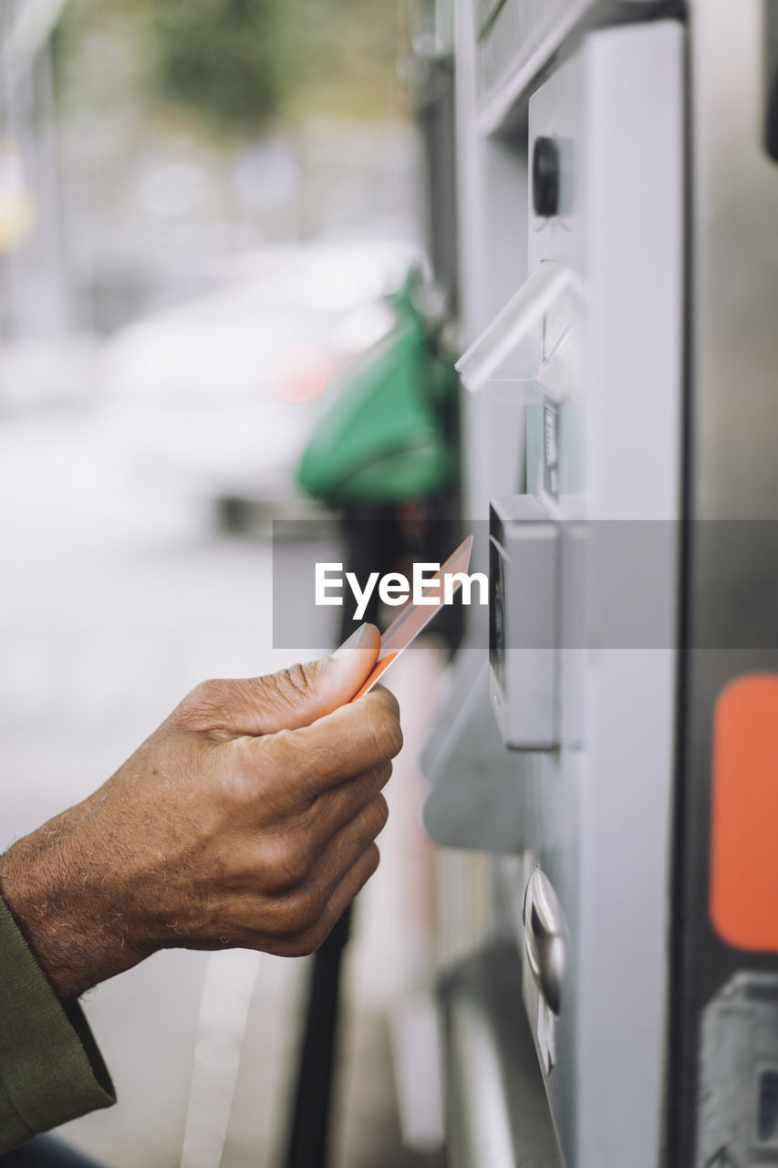 Hand of man doing payment via credit card at gas station