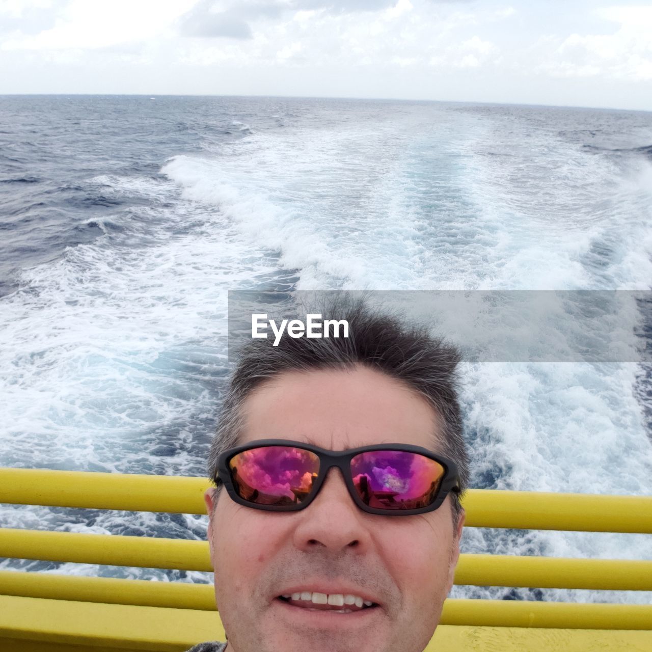 Portrait of man wearing sunglasses on boat sailing in sea