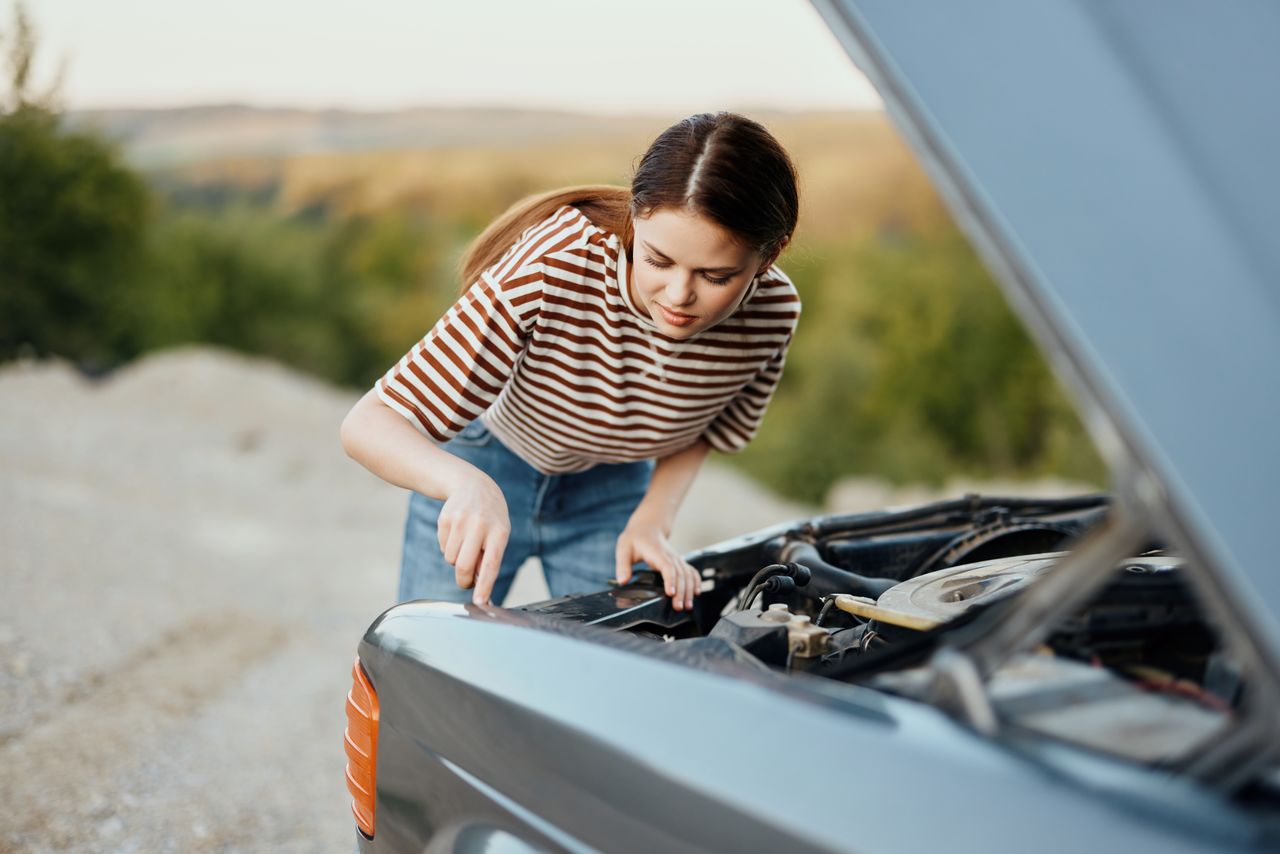 side view of young man sitting on car