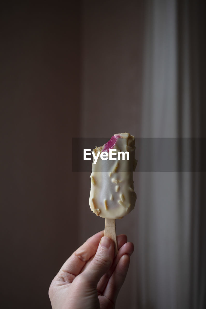 Close-up of hand holding ice cream in plate