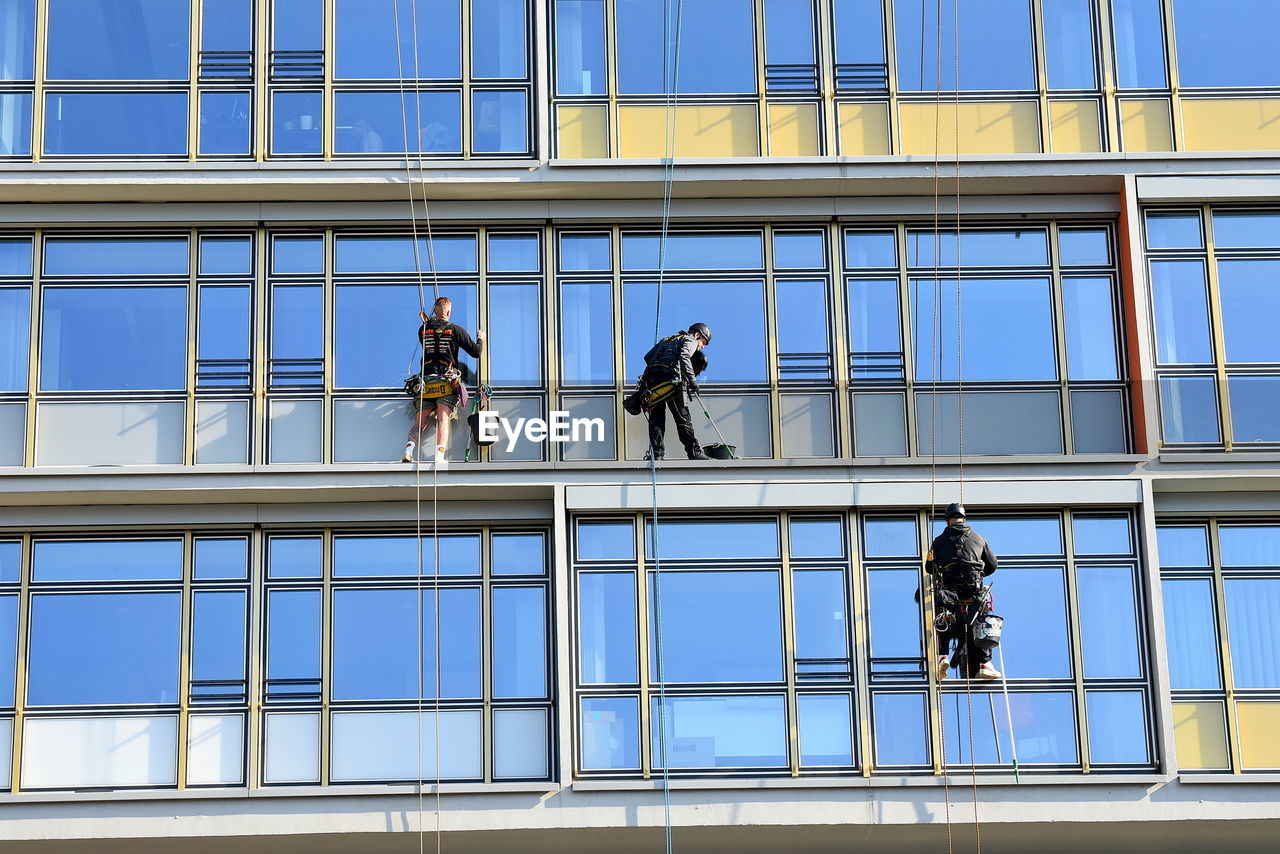 LOW ANGLE VIEW OF PEOPLE WORKING ON BUILDING