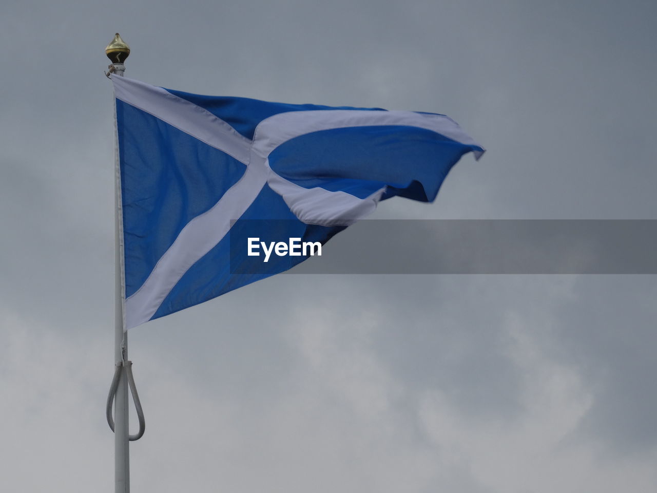Low angle view of scottish flag against cloudy sky