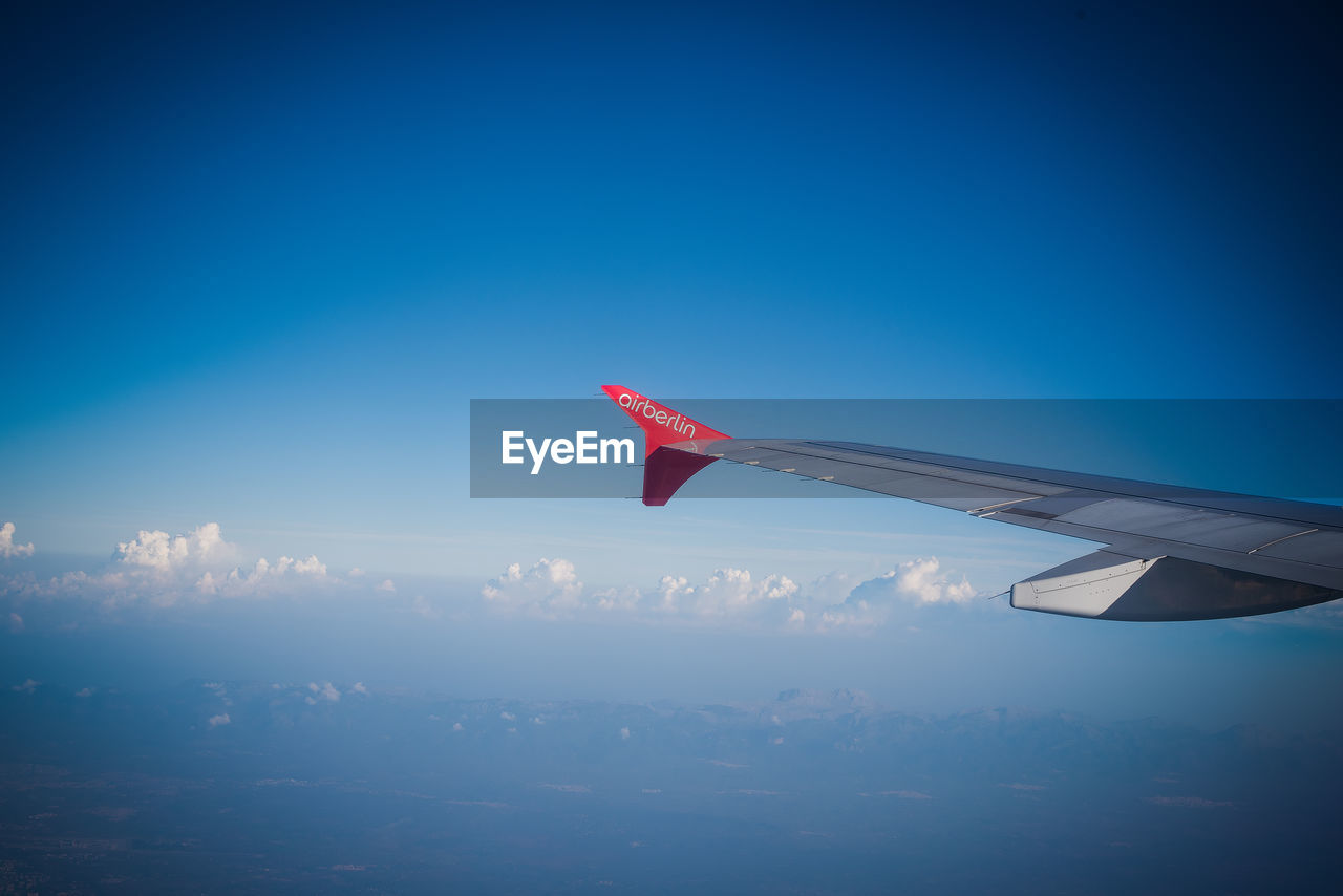 AIRPLANE FLYING AGAINST BLUE SKY